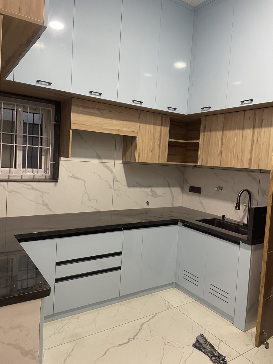 White and wood modular kitchen with black granite counter, Chennai