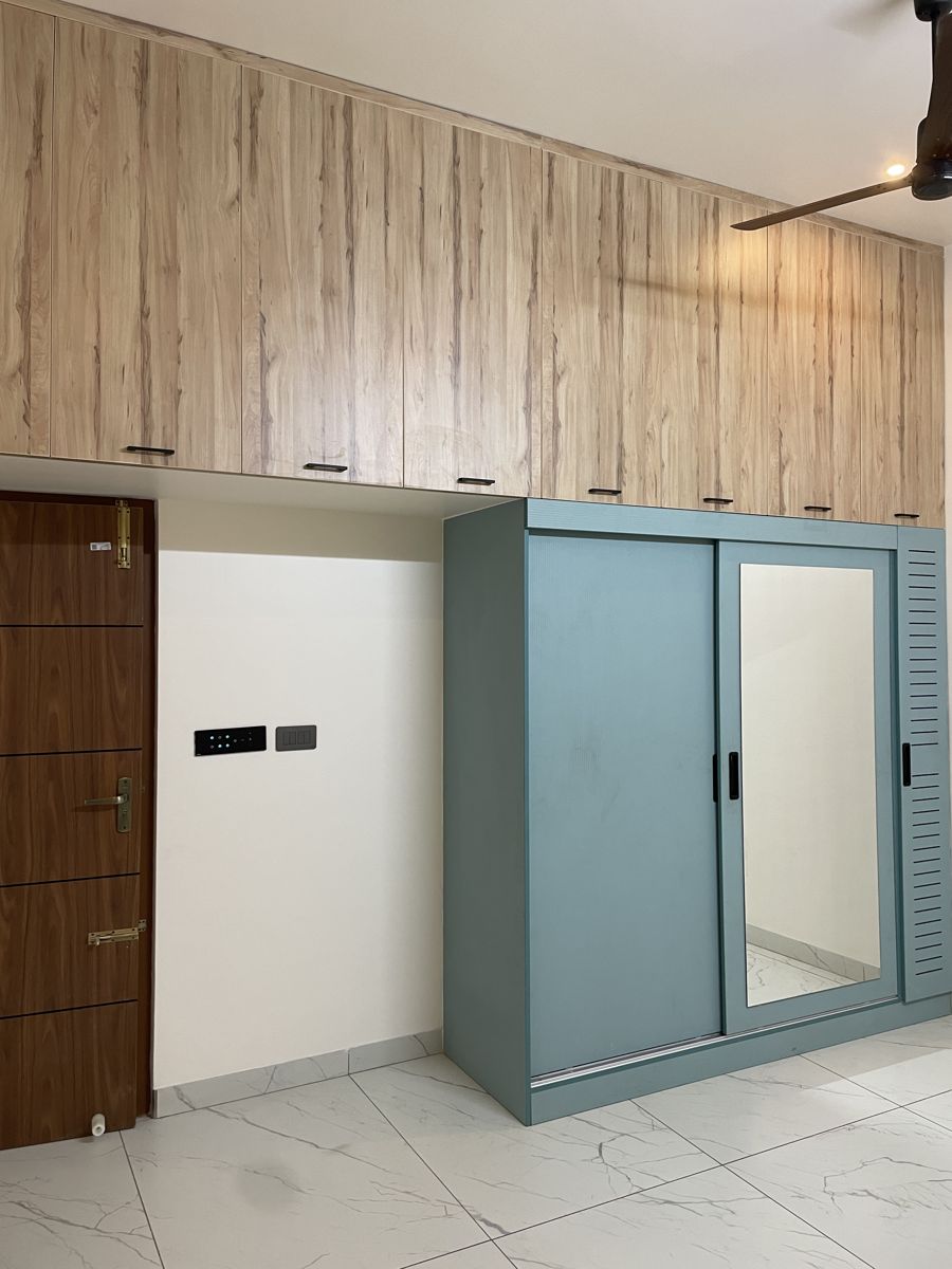 Blue sliding wardrobe in a compact bedroom, Chennai